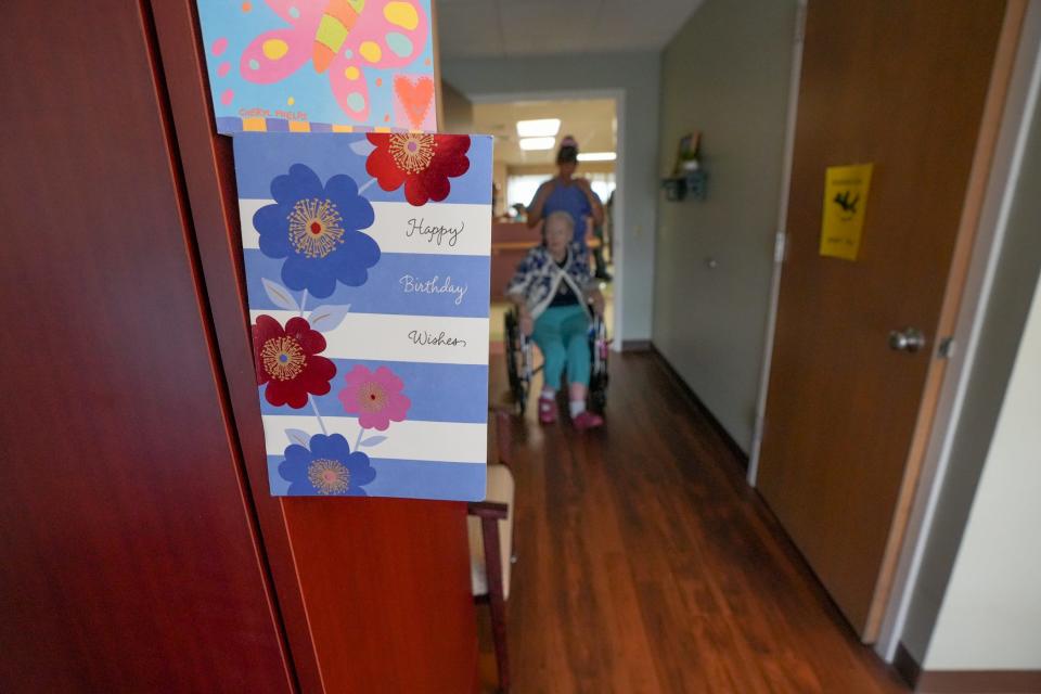 A nurse wheels a resident down a hallway at Aldersbridge Communities in East Providence.