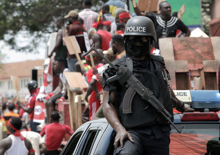 A police officer stands guard as demonstrators take part during a protest against the expansion of its defence cooperation with the United States, in Accra, Ghana March 28, 2018. REUTERS/Francis Kokoroko
