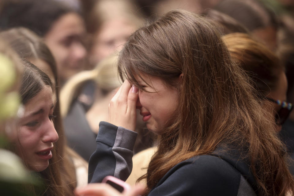 A woman cries as people light candles for the victims near the Vladislav Ribnikar school in Belgrade, Serbia, Thursday, May 4, 2023. A 13-year-old who fire Wednesday at his school in Serbia's capital. He killed eight fellow students and a guard before calling the police and being arrested. Six children and a teacher were also hospitalized. (AP Photo/Armin Durgut)