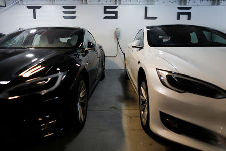FILE PHOTO:Two Tesla Model 3 vehicles are shown charging in an underground parking lot next to a Tesla store in San Diego, California, U.S., May 30, 2018. REUTERS/Mike Blake/File Photo