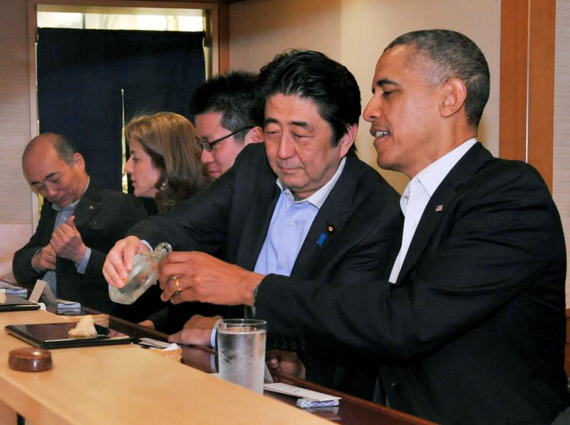 FILE PHOTO : Japanese Prime Minister Shinzo Abe pours sake for U.S. President Barack Obama as they have dinner at the Sukiyabashi Jiro sushi restaurant in Tokyo
