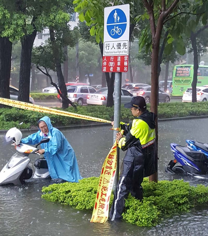 高雄市23日瞬間強降雨不斷，造成多處積水成災，路上有多部汽機車拋錨，交通打結。圖為新興區民生路淹水情形。（警方提供）