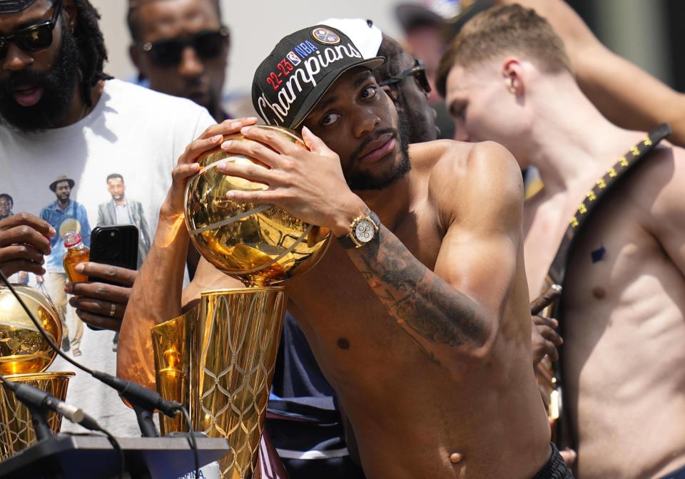 Denver Nuggets forward Bruce Brown hugs the championship trophy during a rally to mark the Denver Nuggets first NBA basketball championship Thursday, June 15, 2023, in Denver. (AP Photo/Jack Dempsey)