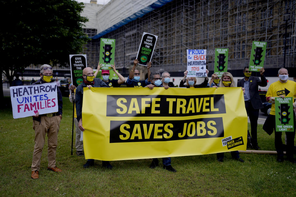 People who work in the UK aviation and travel industry take part in a 'Travel Day of Action' protest across the street from the Houses of Parliament in London, Wednesday, June 23, 2021. The protest on Wednesday was attended by people from across the UK aviation and travel industry calling on the British government to safely reopen international travel for the peak summer season to protect travel jobs and businesses amidst Britain's widely praised rollout of coronavirus vaccines. (AP Photo/Matt Dunham)