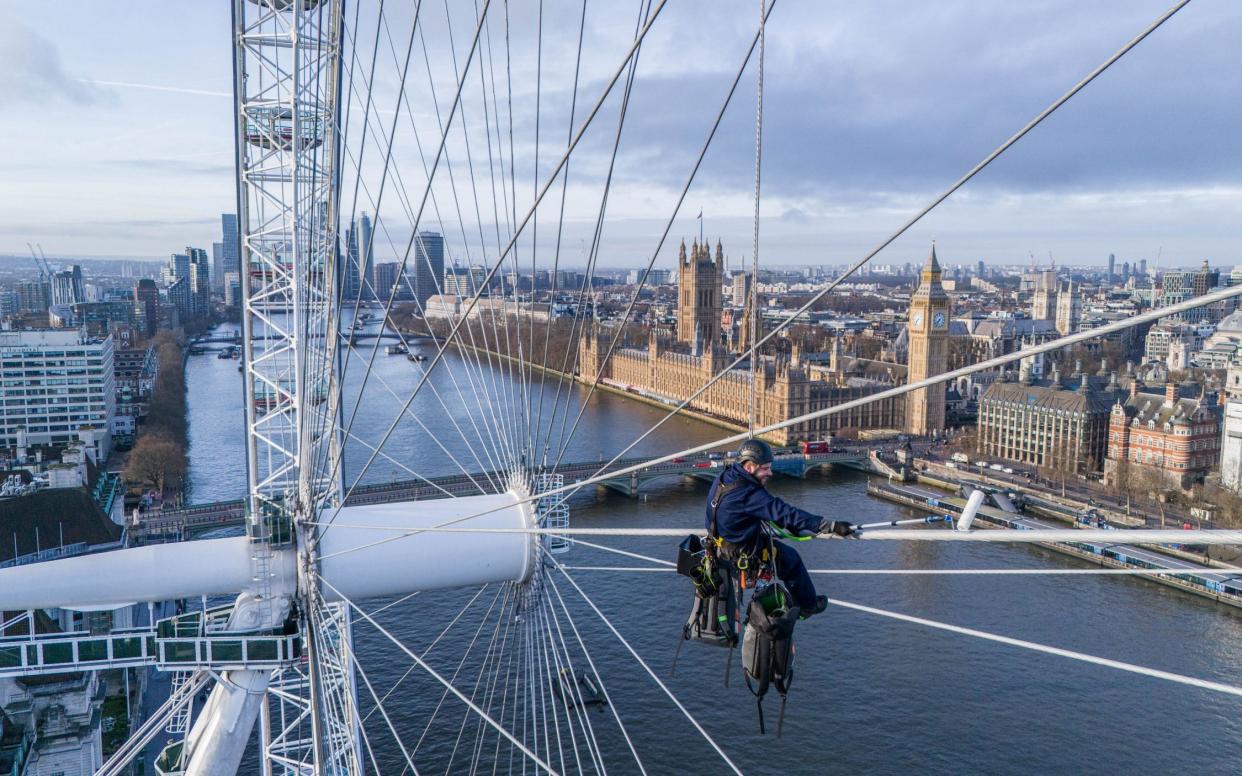 One of the team of painters hanging from the London Eye until June