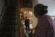 Palden Dorjee peers up the stairs while assisting in a ceremony honoring Guru Rinpoche, the Indian Buddhist master who brought Tantric Buddhism to Tibet, on Monday, July 19, 2021, in Columbia Heights, Minn.. Over two days the group prayed for victims of natural disasters, war and COVID-19, and for the peace and happiness of beings worldwide. (AP Photo/Jessie Wardarski)