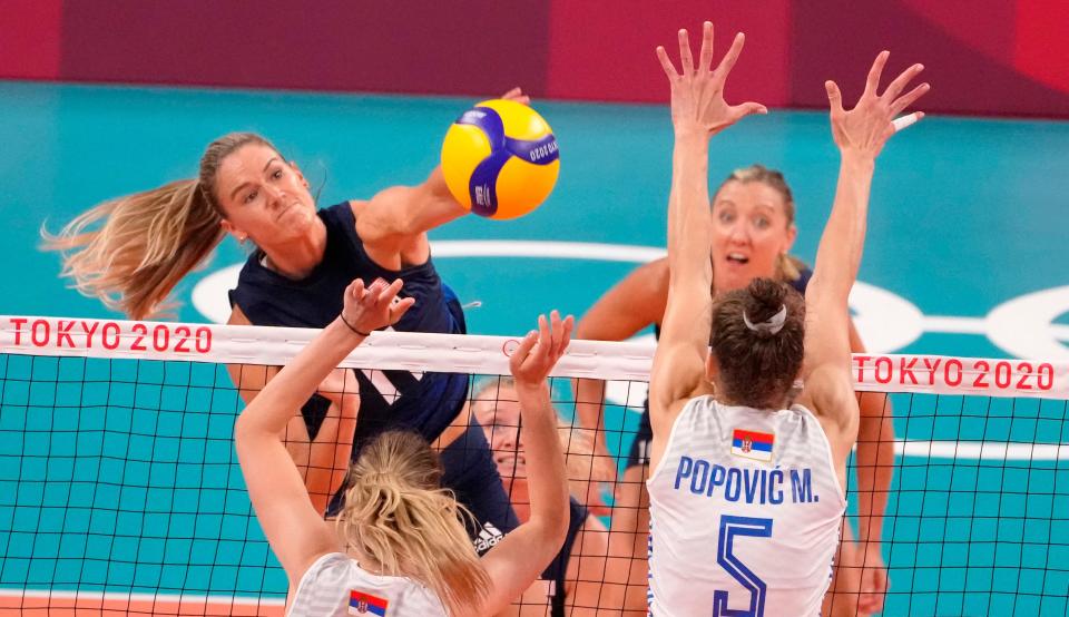 USA player Andrea Drews (11) hits the ball as Serbia player Mina Popovic (5) defends.