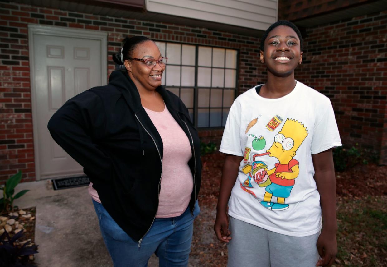 Christian Hooks, 12, along with his mom, Catrina McMillan, outside their Port Orange home Monday, Nov. 21. McMillan used resources from Food Brings Hope after her home and car flooded from Tropical Storm Ian. Christian, a seventh-grader at Campbell Middle School, also participates in the TeenZone program, which is sponsored by Food Brings Hope and provides before- and after-school tutoring, meals, activities and field trips.