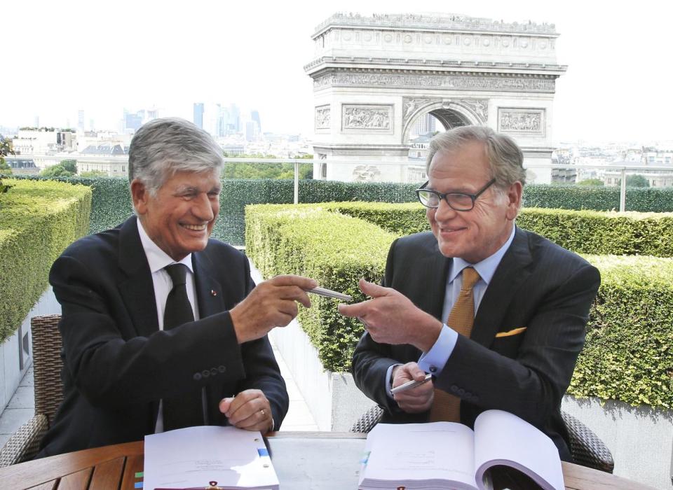 FILE - This Sunday, July 28, 2013, file photo shows Maurice Levy, left, Chief Executive of French advertising group Publicis, and John Wren, head of Omnicom Group exchanging a pencil during a joint signature prior to a news conference in Paris, France. The CEO of Publicis Groupe, Maurice Levy, says the planned deal with Omnicom to create the world's largest advertising firm collapsed over unresolvable differences over how to implement a "merger of equals." The merger announced in July was intended to help the firms counter the growing clout of Internet giants such as Facebook and Google, which can bypass advertising companies altogether, as well as strengthen growth in Asia and Latin America. (AP Photo/Francois Mori, File)