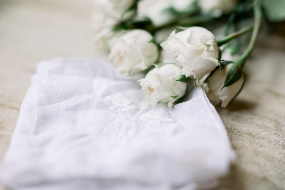 White Roses Lying Next to a White Embroidered Old-Fashioned Handkerchief, Wedding Photo