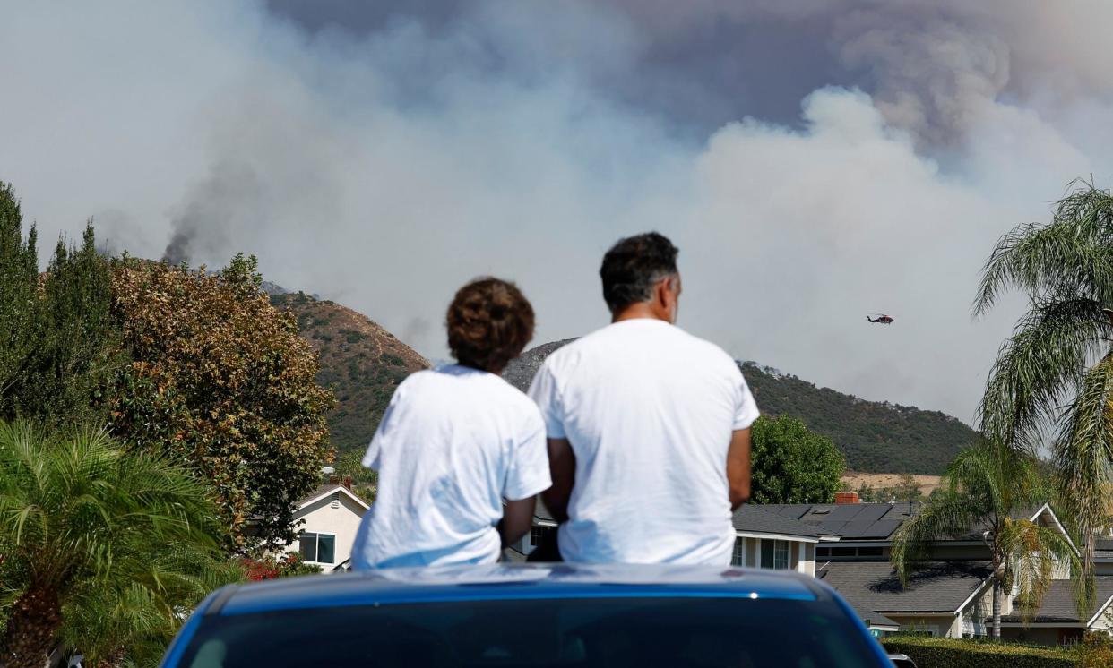 <span>The Airport fire, one of several wildfires in the greater Los Angeles area, burns in Trabuco Canyon on Tuesday.</span><span>Photograph: Caroline Brehman/EPA</span>