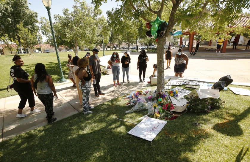 PALMDALE, CA - JUNE 15: People gather at a memorial under a tree for Robert Fuller in Poncitlan Square next to Palmdale City Hall where Fuller, a young black man was found hung last week. Nearby protestors are stationed at the doors to Palmdale City Hall which remain closed Monday morning with protestors stationed at each entry door with a sit-in at Palmdale City Hall as organizers demand justice for Robert Fuller, the young black man who was found hung in Poncitlan Square last week. The group is seeking more information on Fuller's case, including the release of the 911 call and the autopsy report. Palmdale City Hall on Monday, June 15, 2020 in Palmdale, CA. (Al Seib / Los Angeles Times)