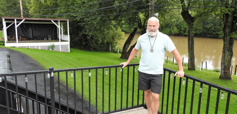 Jeffrey Peters of Carroll stands on the back patio of the Boathouse Tavern, which he recently bought from Dave and Sharon Tatro. He wants to bring a variety of acts to the outdoor stage and sees the river access as a major asset.