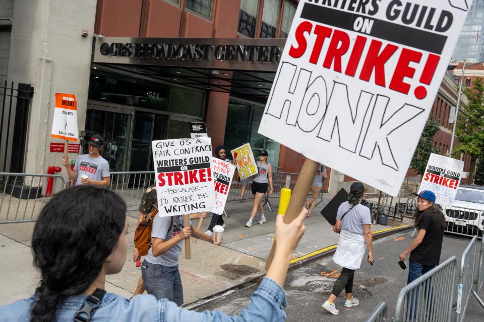 WGA members hold picket signs as they strike outside of NYC's CBS building where "The Drew Barrymore Show" is taped.