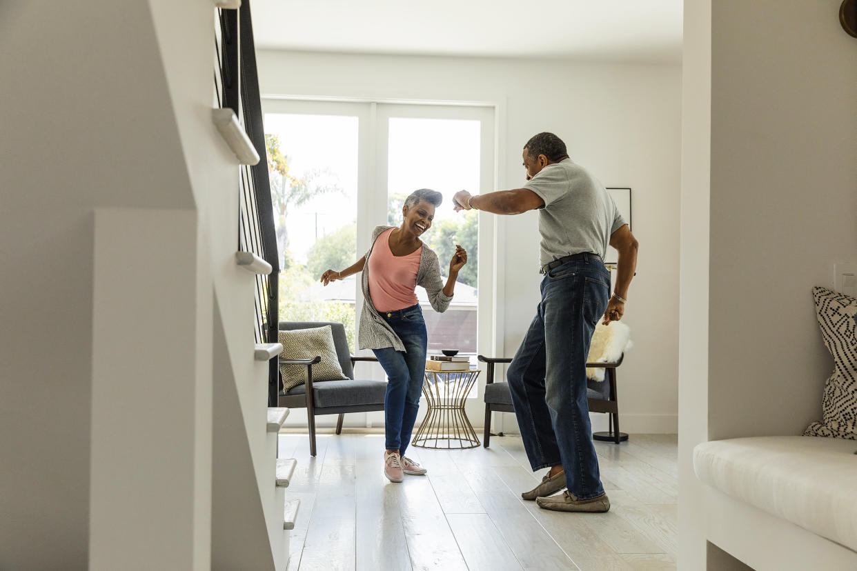 Mature couple dancing in living room. (Getty Images)