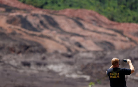 A federal police officer takes picture of the collapsed Brazilian mining company Vale SA, in Brumadinho, Brazil February 1, 2019. REUTERS/Adriano Machado