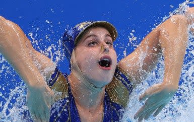 Close-up of one swimmer's facial expression, eyes looking up and mouth wide open