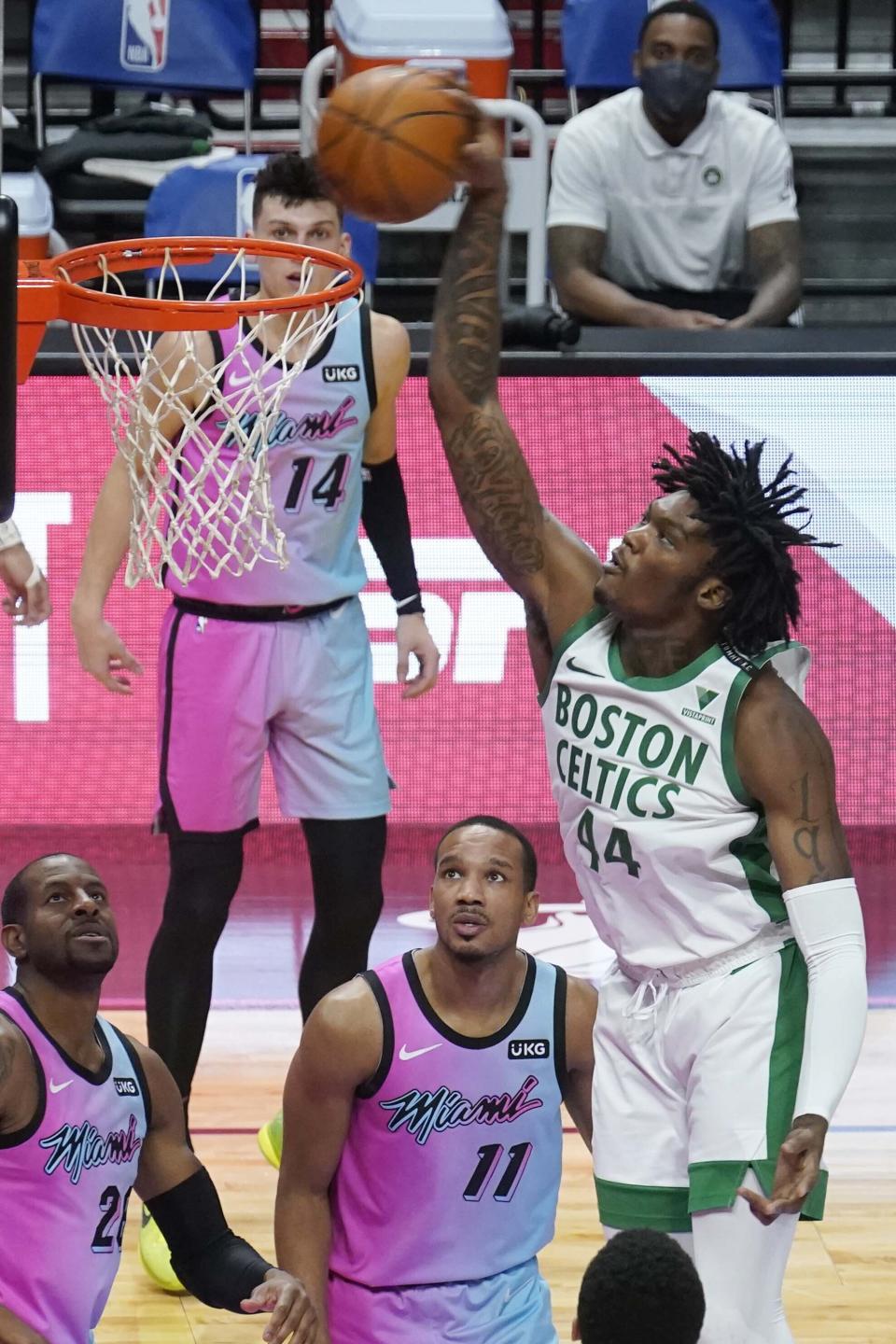 Boston Celtics center Robert Williams III (44) dunks the ball over Miami Heat guards Avery Bradley (11) and Andre Iguodala (28) during the second half of an NBA basketball game, Wednesday, Jan. 6, 2021, in Miami. (AP Photo/Marta Lavandier)