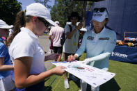 Jin Young Ko, of South Korea, right, signs autographs after a practice round for the the U.S. Women's Open golf tournament at the Pine Needles Lodge & Golf Club in Southern Pines, N.C. on Tuesday, May 31, 2022. (AP Photo/Chris Carlson)