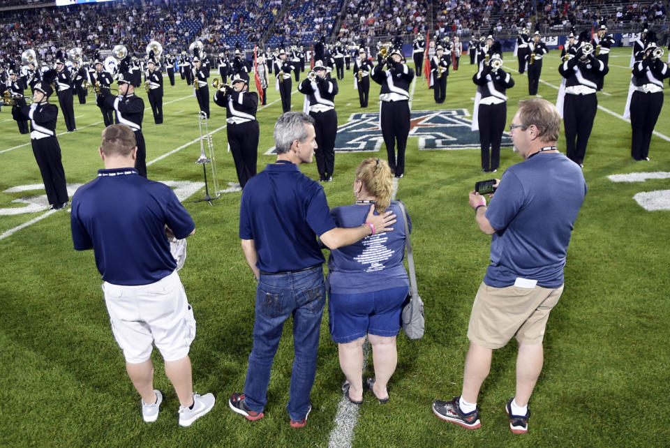 Max Schachter, second from left, the father of Alex Schachter, who was killed in the February shooting at Marjory Stoneman Douglas High School, watches the UConn marching band play during the halftime show dedicated to his son at the Huskies’ season opener against Central Florida on Thursday. From left are Tim Goldberg, Alex’s cousin; Schachter; Patti Goldberg, aunt; and Paul Goldberg, uncle. (AP Photo/Stephen Dunn)