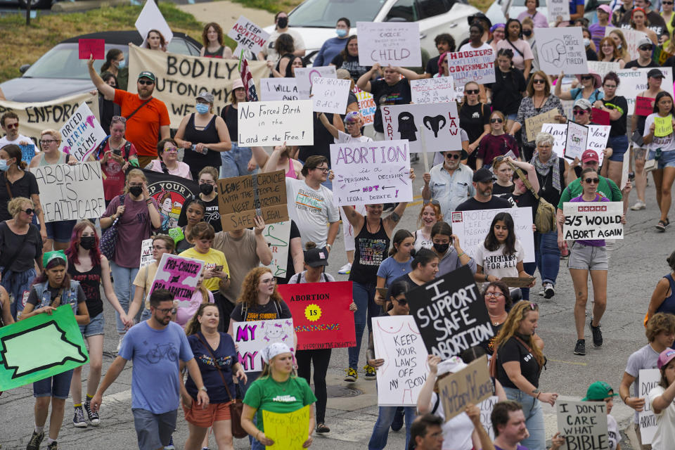 FILE - Abortion-rights protestors march between the Indiana Statehouse and the Indiana State Library where Vice President Kamala Harris was meeting with Indiana legislators to discuss reproductive rights in Indianapolis on July 25, 2022. Indiana's high court will not immediately take up a religious-freedoms challenge to the state's abortion ban, leaving that decision for now with an appeals court, documents from Monday, Jan. 30, 2023 show. (AP Photo/Michael Conroy, File)