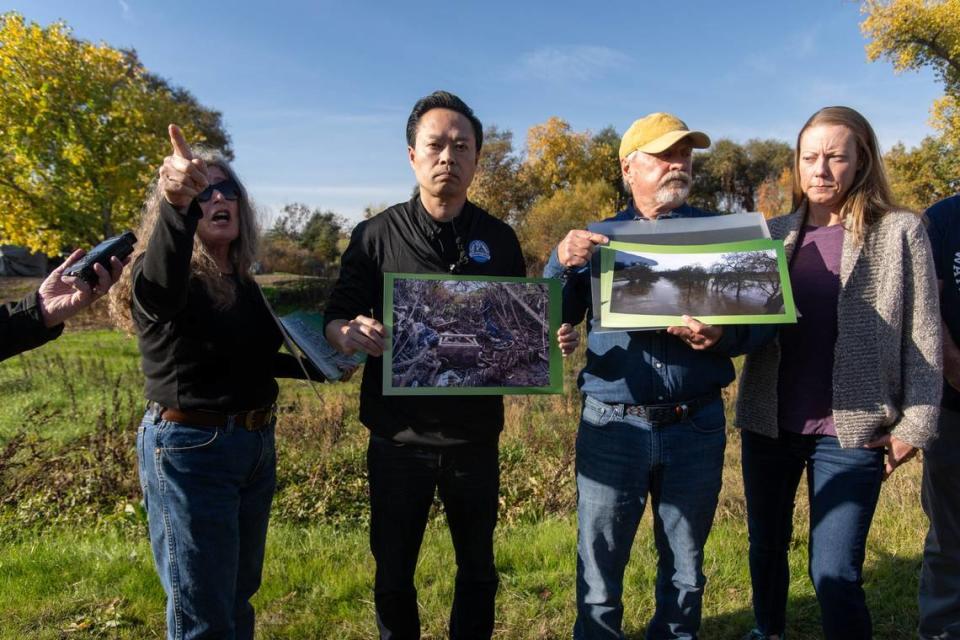 Sacramento County District Attorney Thien Ho holds photos with the River City Waterway Alliance’s Crystal Tobias, left, and Roland Brady illustrating the environmental, health and safety issues caused by homeless encampments during a tour at Steelhead Creek in Sacramento on Tuesday, Dec. 5, 2023.