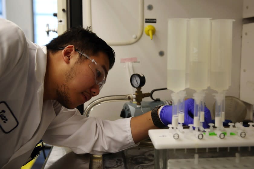 Dania Maxwell  Los Angeles Times TWAN NGUYEN examines a machine testing water for chemicals at the Orange County Water District.