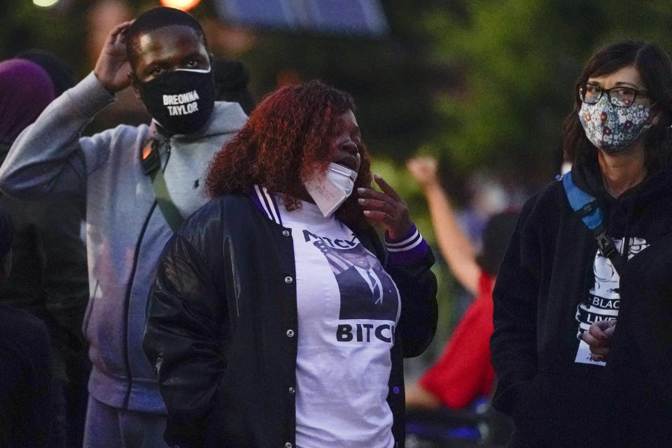 Tamika Palmer, center, the mother of Breonna Taylor stands with demonstrators, Thursday, Sept. 24, 2020, in Louisville, Ky. Authorities pleaded for calm while activists vowed to fight on Thursday in Kentucky's largest city, where a gunman wounded two police officers during anguished protests following the decision not to charge officers for killing Breonna Taylor. (AP Photo/Darron Cummings)