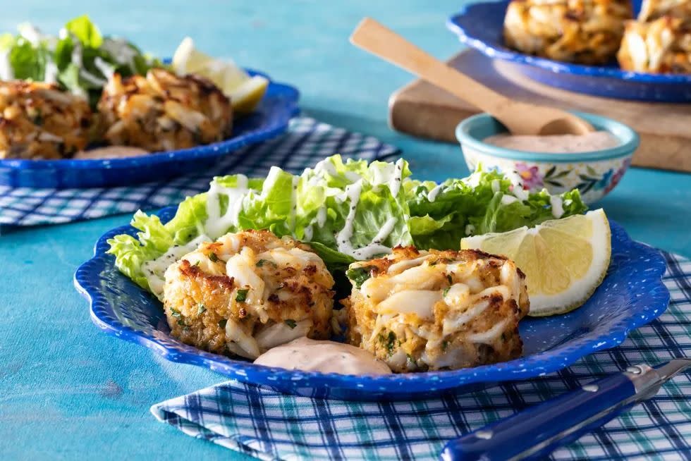 crab cakes with side salad and mayo on blue plate