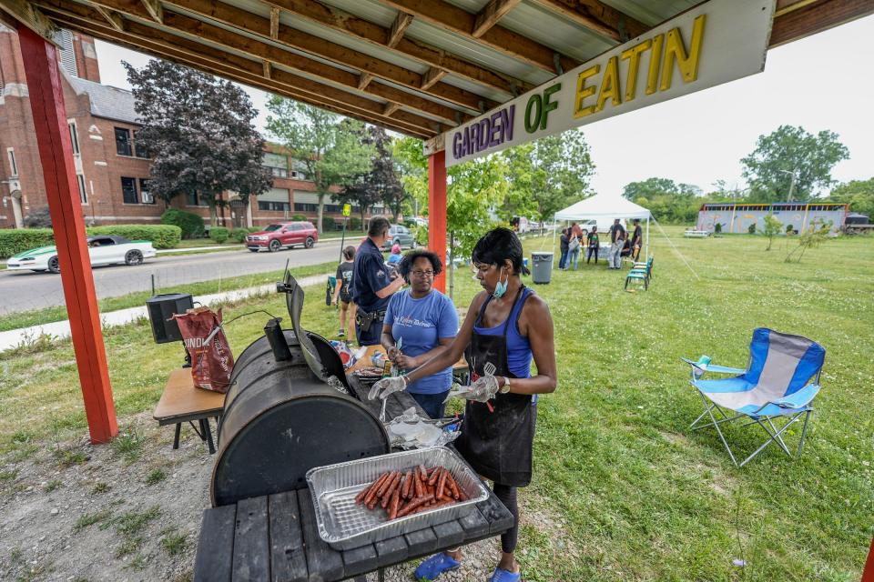 Maisha Griswold, 45, of Camp Restore Detroit, assists Rochelle Bones, 61, of Detroit, on the barbecue pit during a "Pop-up" where free food was served to the community in the "red zone" blocks away where a shooting injured 19 people and killed two, on Tuesday, July 9, 2024. Ms. Bones Soul Food volunteered to barbecue. Griswold, of Camp Restore Detroit, says food is just the attraction. “Once we get them in we can let them know how we are trying to have an impact in our community. If you want to see change you have to be the change.