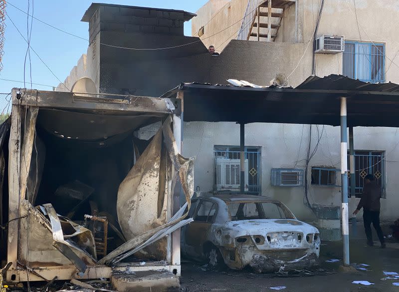 A damaged police station and vehicles which were destroyed last night are pictured during the ongoing anti-government protest in Nassiriya