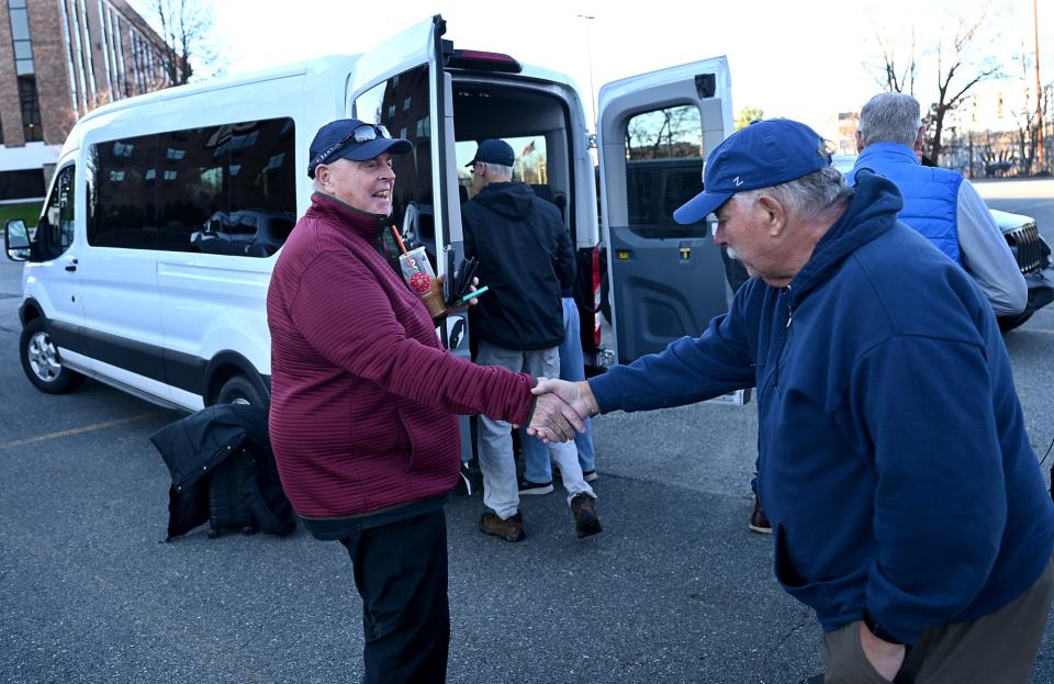 Jack Trabucco, left, shakes hands with Dan Gower before heading to the Army/Navy football game  with a group of friends, at the Sheraton Framingham Hotel, Dec. 9, 2022.  