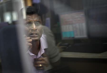 A broker looks at a computer screen as he talks on a phone at a stock brokerage firm in Mumbai December 3, 2012. REUTERS/Danish Siddiqui/Files