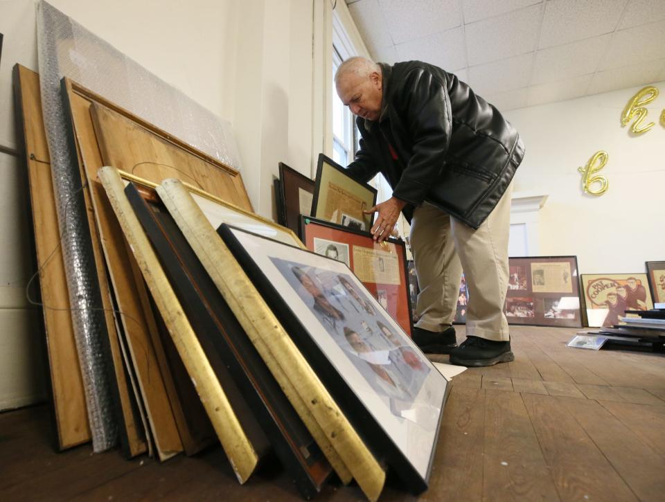 Ed George rummages through framed posters and autographed photos of celebrities who came to Tangier in Akron.