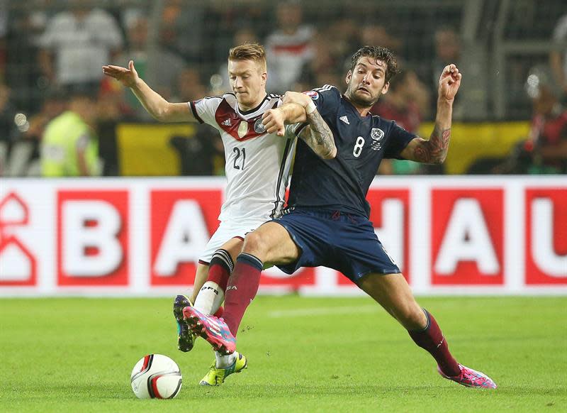 DUS701. Dortmund (Germany), 07/09/2014.- Marco Reus (izquierda) lucha el balón con el escocés Charlie Mulgrew (derecha) durante un partido de la Eliminatoria de la Copa de Europa 2016. EFE/EPA/KEVIN KUREK