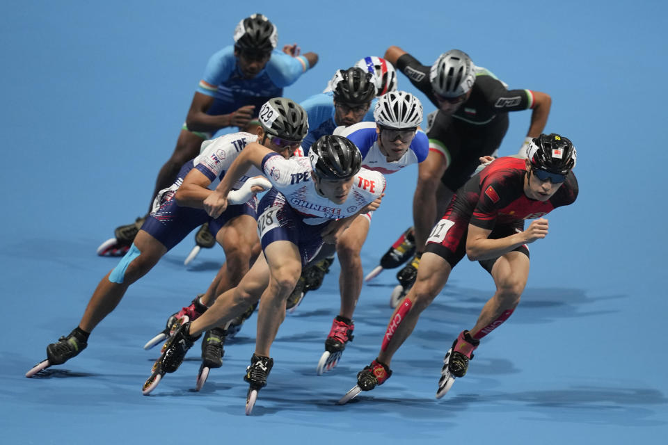 Zhenhai Zhang, right, of China, and Yan-Cheng Chen, left, of Taiwan, compete during the men's Speed Skating 10000m Point-Elimination Race event of the 19th Asian Games in Hangzhou, China, Saturday, Sept. 30, 2023. (AP Photo/Aaron Favila)