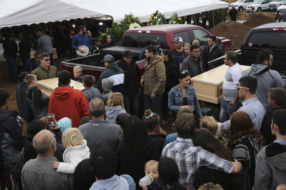 Family and friends unload the coffins that contain the remains of Rhonita Miller and four of her young children Krystal and Howard, and twins Titus and Tiana, who were murdered by drug cartel gunmen earlier in the week, for a burial service at the cemetery in Colonia Le Baron, Mexico, Friday, Nov. 8, 2019. The bodies of Miller and four of her children were taken in a convoy of pickup trucks and SUVS, on the same dirt-and-rock mountainous road where they were killed Monday, for burial in the community of Colonia Le Baron in Chihuahua state. (AP Photo/Marco Ugarte)