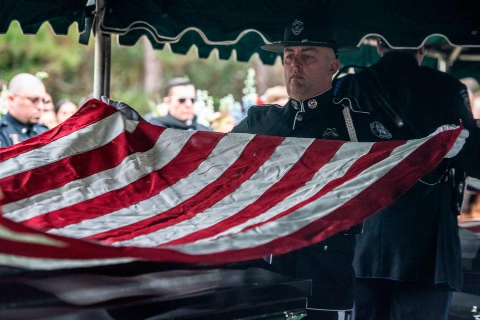 Honor guard officers prepare to fold the American flags laying over the caskets of Bay St. Louis police officers Sgt. Steven Robin and Branden Estorffe during their gravesite ceremonies at Gardens of Memory cemetery in Bay St. Louis on Wednesday, Dec. 21, 2022. Robin and Estorffe were killed responding to a call at a Motel 6 on Dec. 14.