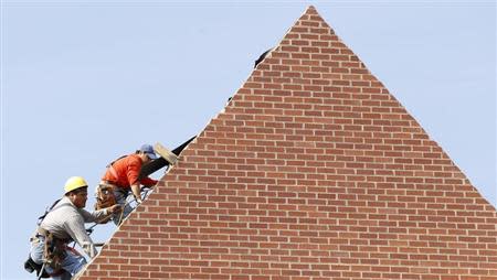 Builders work on the roof of a new housing construction site in Alexandria, Virginia October 17, 2012. REUTERS/Kevin Lamarque