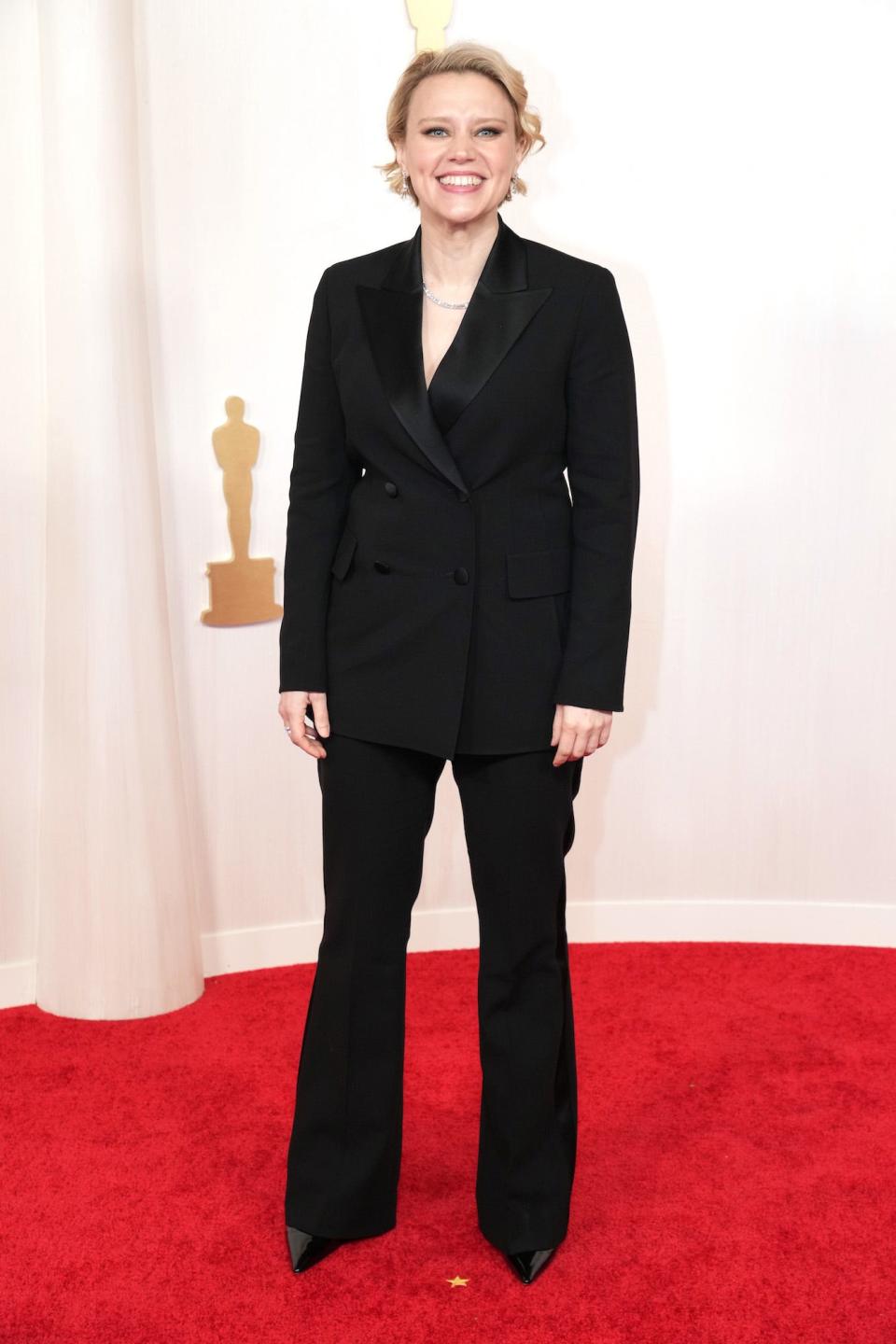 Kate McKinnon in a black suit.