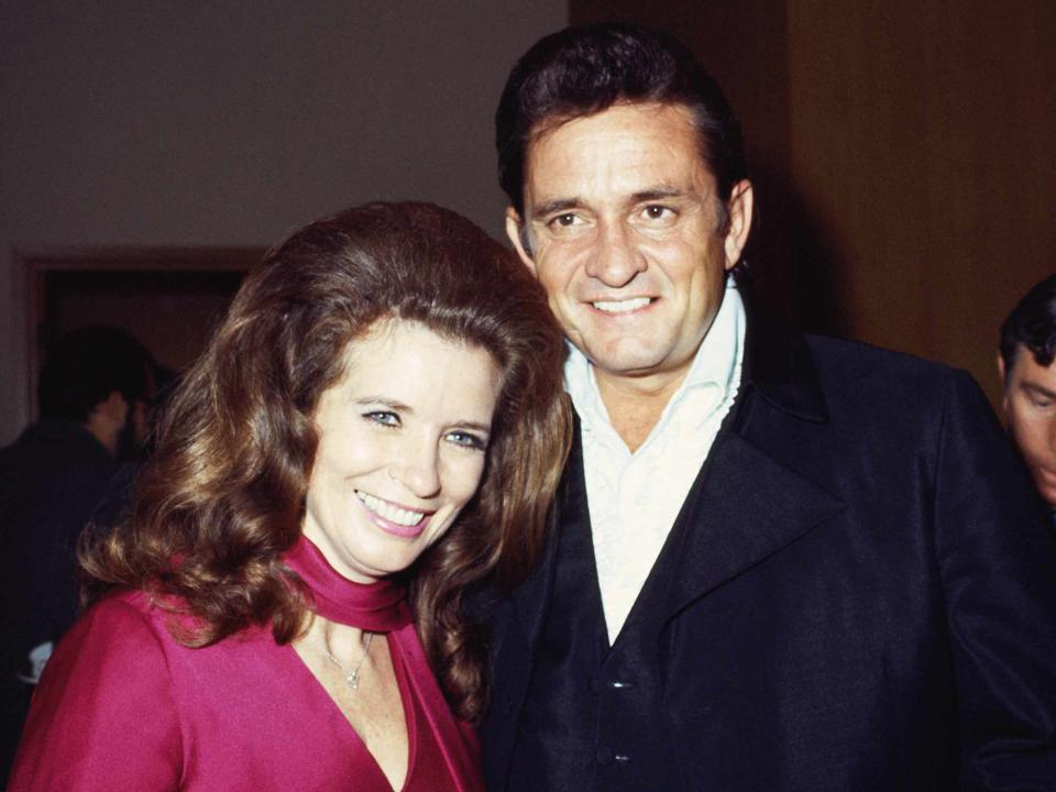 <p>Michael Ochs Archives/Getty</p> Johnny Cash and his wife June Carter Cash pose for a portrait at an event in September 1969.
