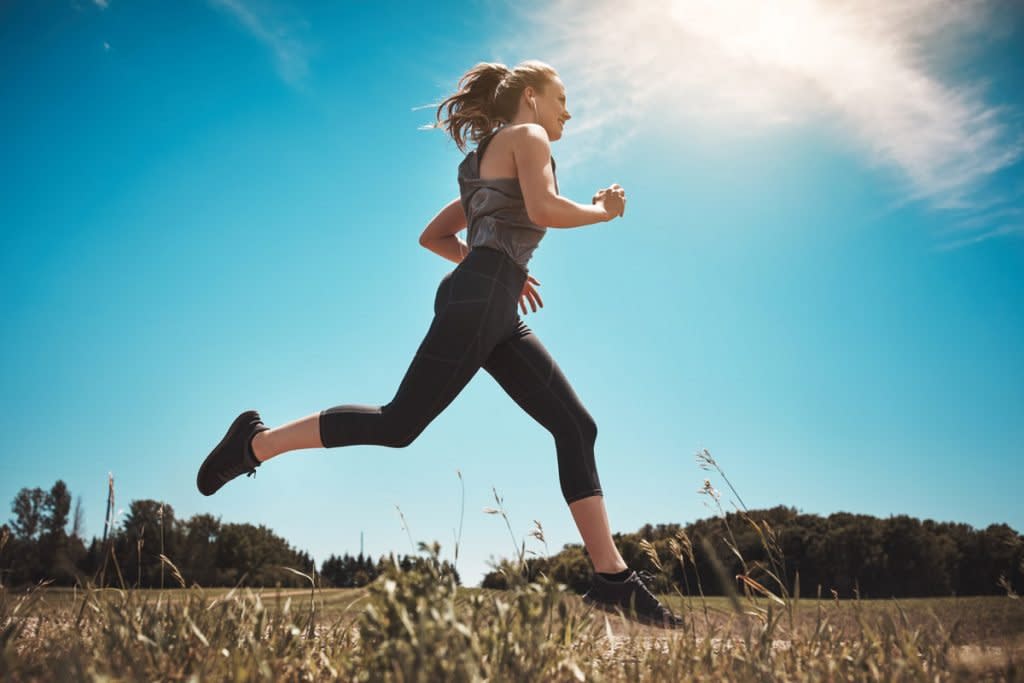 A woman runs in a field.