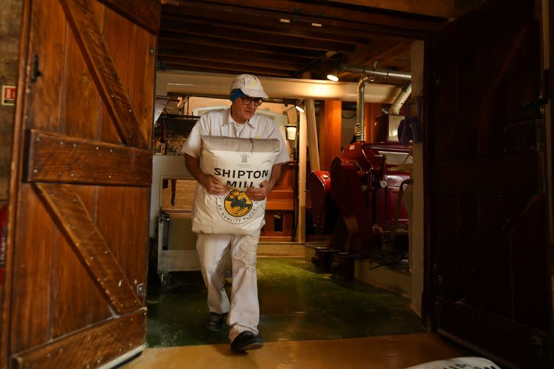 A worker carries a packet of flour inside the family run Shipton Mill in Tetbury