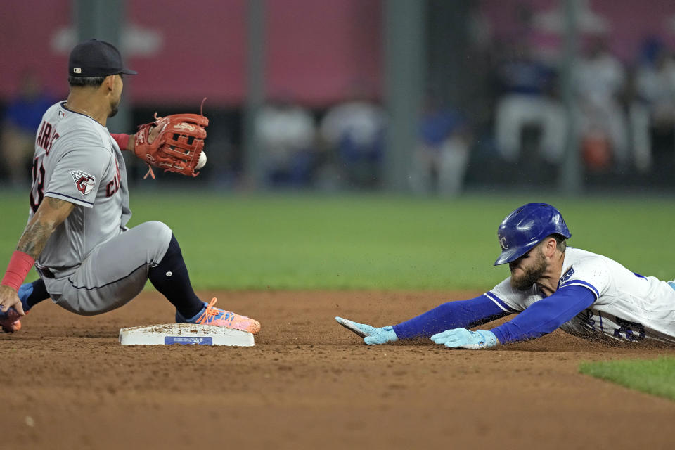 Kansas City Royals' Kyle Isbel, right, beats the tag by Cleveland Guardians shortstop Gabriel Arias after hitting a double during the third inning of a baseball game Tuesday, Sept. 19, 2023, in Kansas City, Mo. (AP Photo/Charlie Riedel)