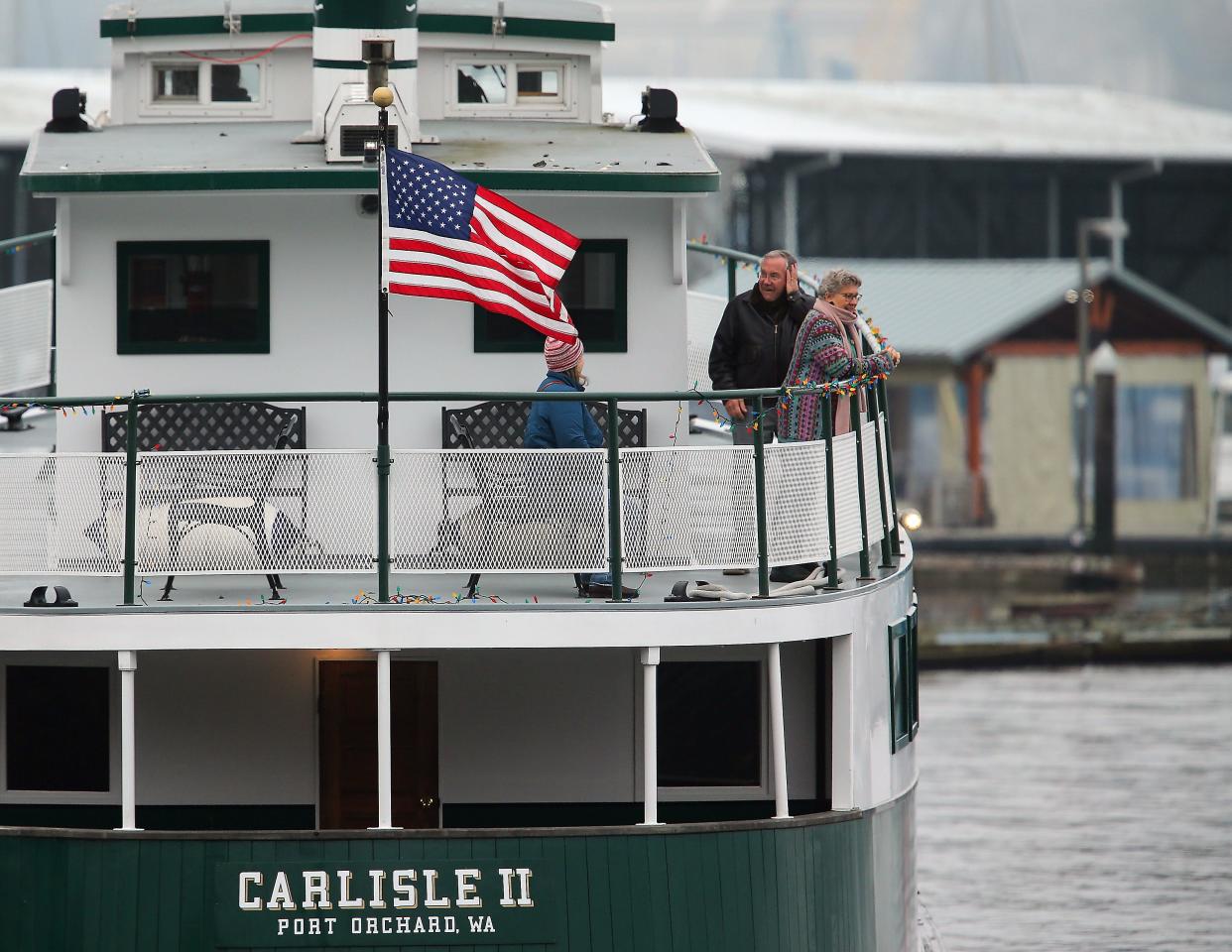 Passengers brave the cold breeze to take in the foggy view from the deck of Kitsap Transit’s Carlisle II as it heads from Port Orchard to Bremerton on Monday, Nov. 27, 2023.