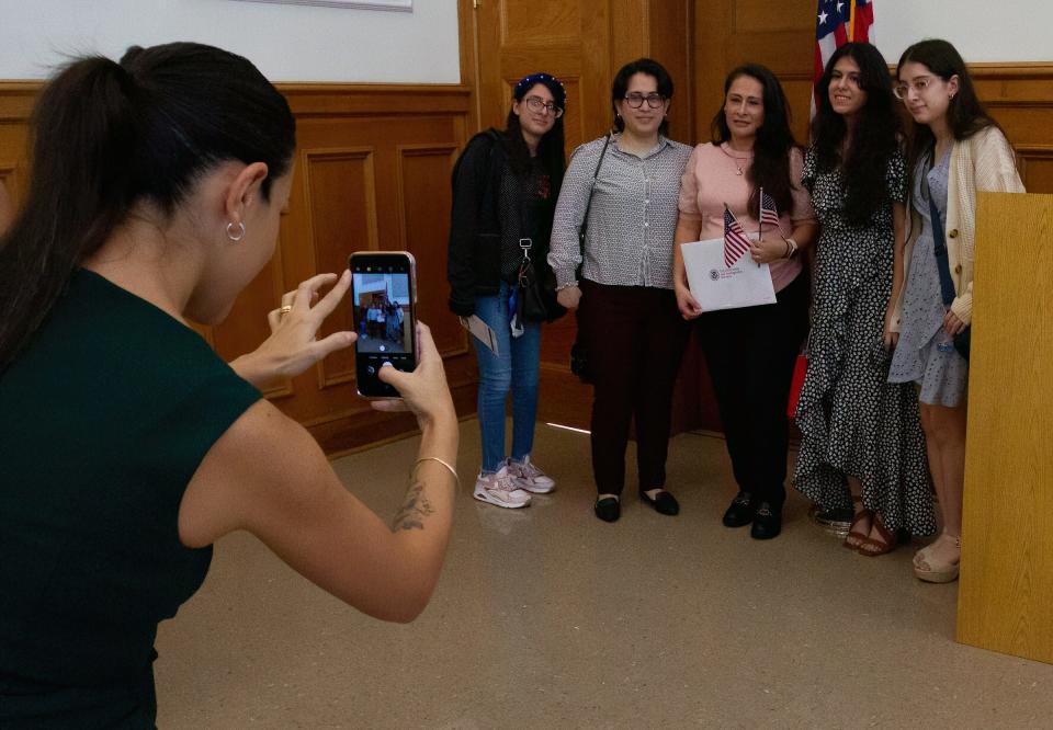 A new American citizen poses with family members following an a naturalization ceremony Friday morning at the Polk History Center in Bartow. About 30 applicants gained citizenship in each of the ceremonies.