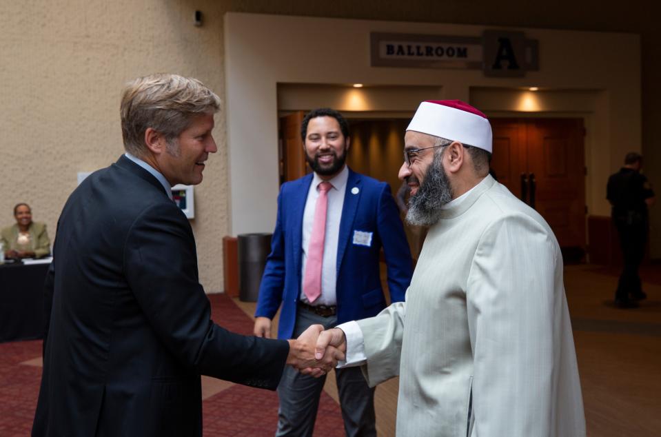 At left, TIm Keller, mayor for the city  of Albuquerque, New Mexico, greets Albuquerquue Islamic Center Imam Talha Elsayed during an interfaith breakfast held at the Albuquerque Convention Center on  August 11, 2022.  