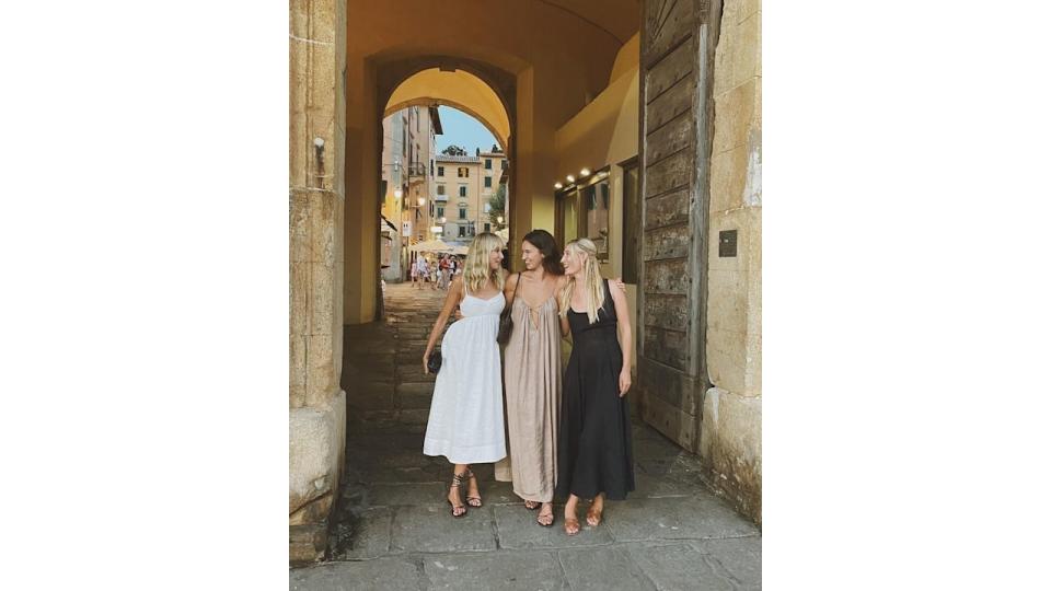 Three women standing in an archway in summer clothes