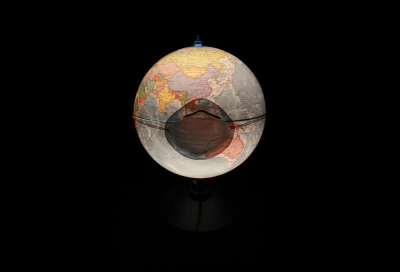 A protective mask is pictured on a table world globe in this illustration