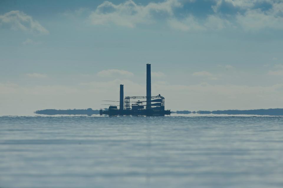 A giant ship carrying partially assembled towers for the Vineyard Wind offshore wind project is seen in the distance as seen from Round Hill beach in Dartmouth.